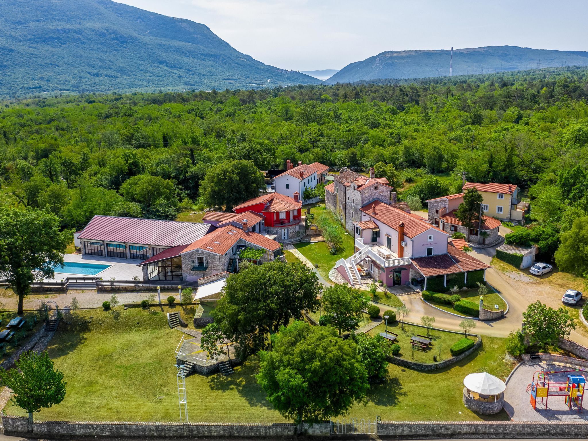 Zona residencial con casas, piscina y parque infantil.