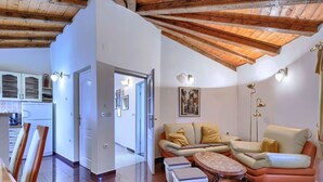 A spacious living area with a high ceiling, a sofa set, a coffee table, and a kitchen in the background. - Rotonda by Interhome (Labin)