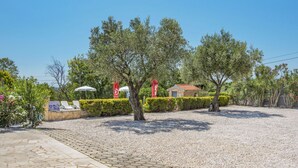 A paved outdoor area with neatly trimmed hedges, a small building with a red-tiled roof, and a statue. - Apartment Jukić by Interhome (Poreč/Kaštelir)