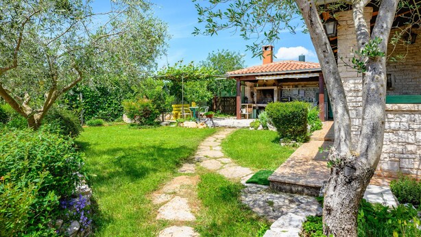 A stone house with a tiled roof, a garden with a stone pathway, and a pergola. - Apartment Pina by Interhome (Pazin)