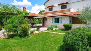 A two-story house with a stone facade, a tiled roof, and a well-maintained garden. - Apartment Pina by Interhome (Pazin)