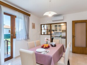 Enjoy meals in this cozy dining area with a table set for two, featuring a centerpiece of fresh fruit.