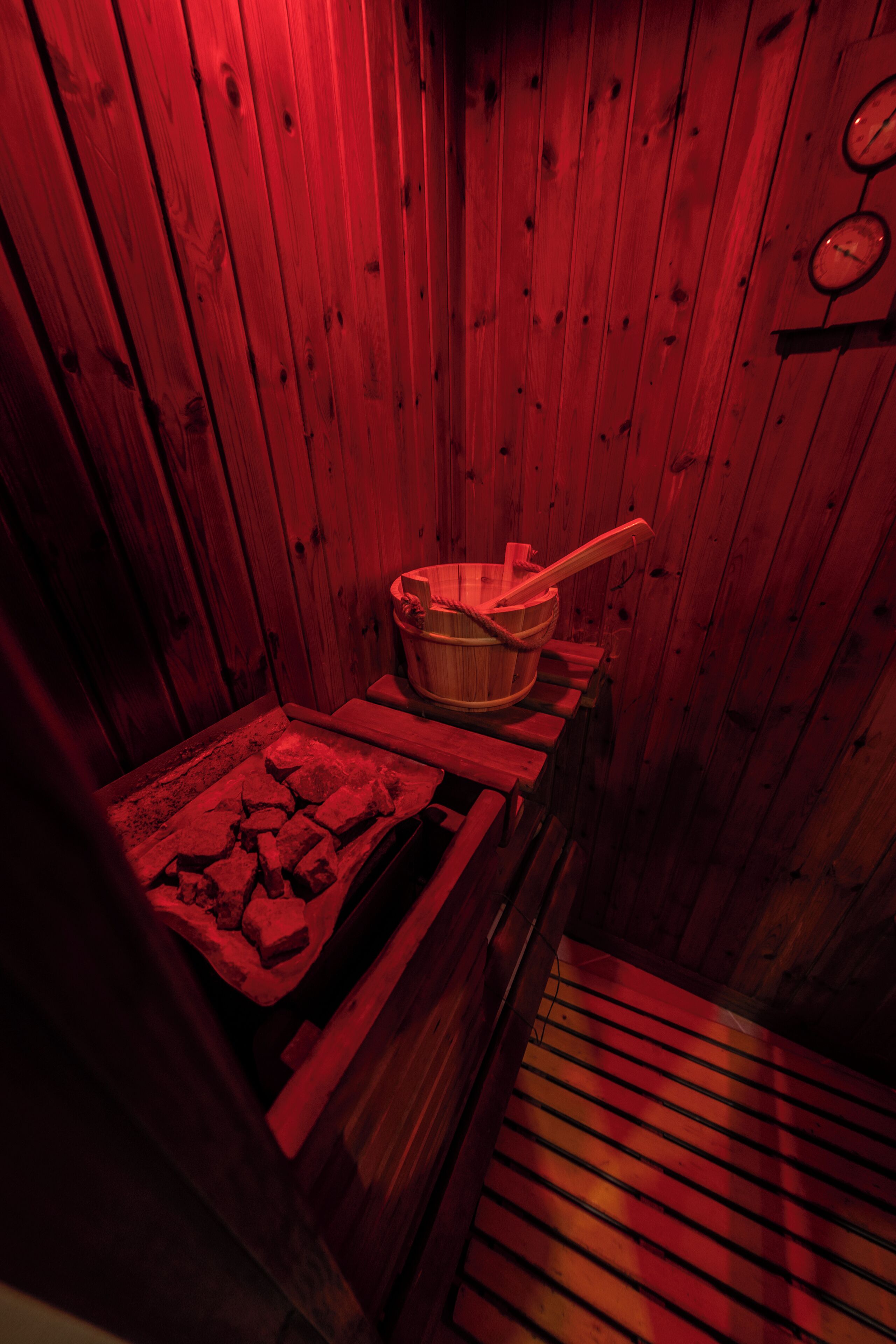 A sauna room with wooden walls and a bench.