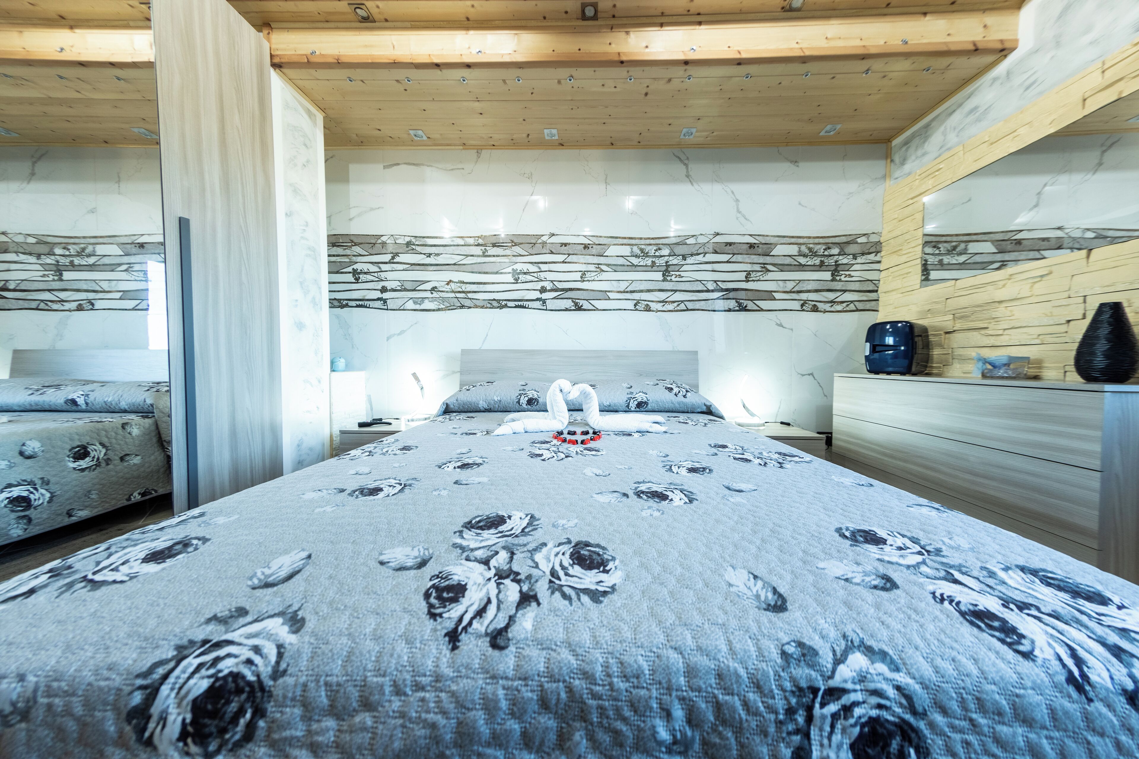 A bedroom with a large bed, a dresser, and a mirror.