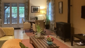 Ein Wohnzimmer mit einer Couch, einem Couchtisch, einem Kamin und einem Essbereich mit Stühlen und Tisch.