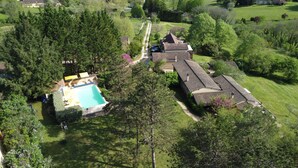Eine Vogelperspektive eines Wohngebiets mit Swimmingpool, überdachter Terrasse und einem Haus mit Ziegeldach.