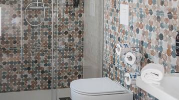 Une salle de bain équipée d’une douche, de toilettes et d’un bidet.