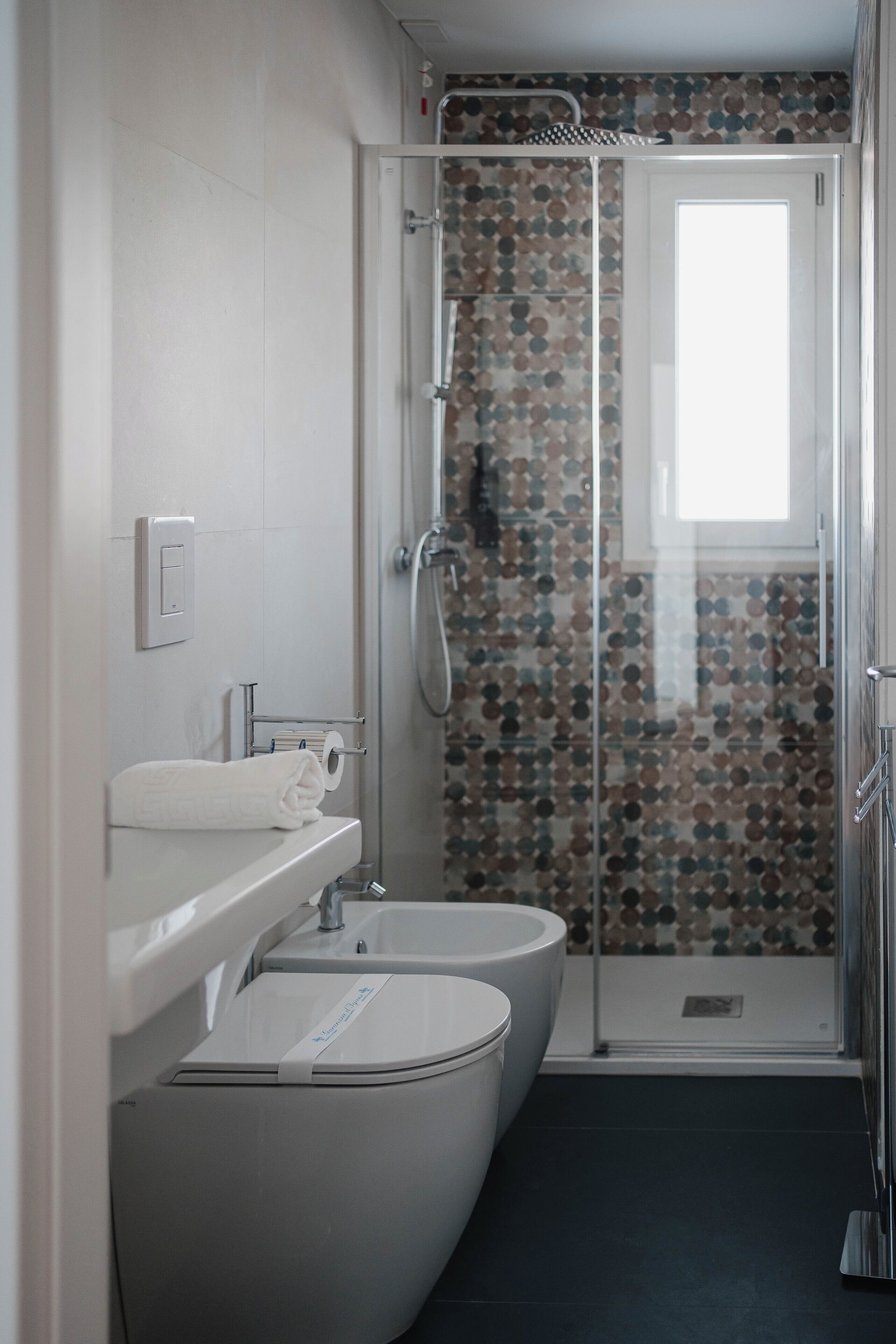 A modern bathroom with a toilet, sink, and shower.