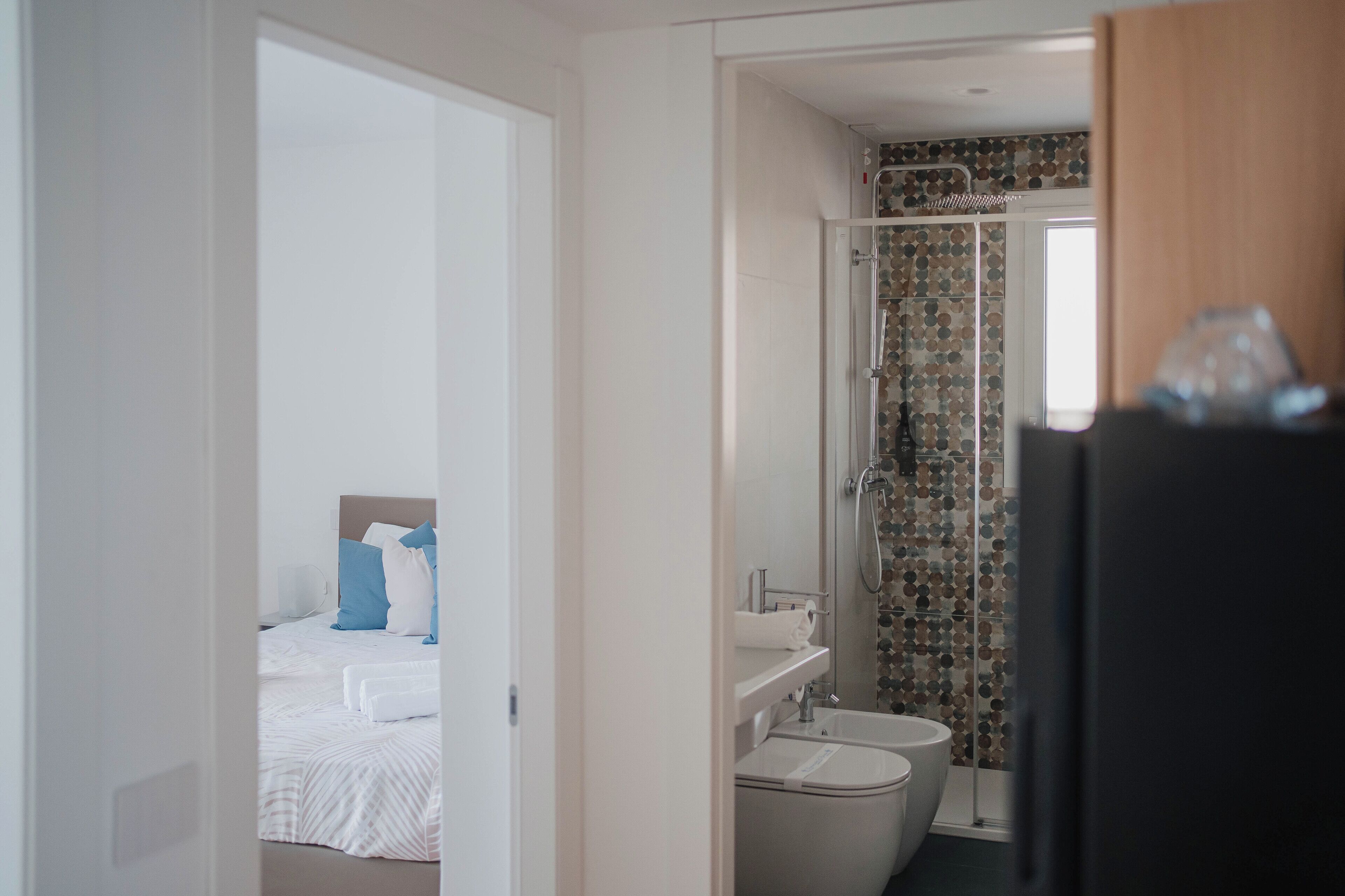 A modern bathroom with a shower, toilet, and sink.
