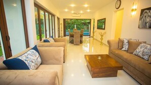 A spacious living area with a sofa set, a coffee table, and a dining table with chairs. - Villa Senaya (Galle)