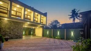 A modern building with a spacious courtyard, stone walls, and illuminated windows. - Villa Senaya (Galle)