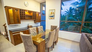 A modern kitchen with wooden cabinets and a glass dining table. - Villa Senaya (Galle)
