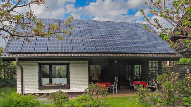 A house with a solar panel roof, a covered patio with outdoor seating, and a garden area. - Katarina I by Interhome (Plau am See)