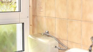 A bathroom with a toilet, sink, and window. - Katarina I by Interhome (Plau am See)