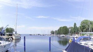 A marina with boats docked, a crane, and a dock with a covered area.