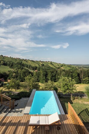Alberca al aire libre, sombrillas en la alberca y camastros 