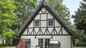 A traditional half-timbered house with a patio, outdoor seating, and a small garden. - Hühnerhaus by Interhome (Schwarbe)