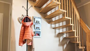 A staircase with wooden steps and a coat rack with a puffer jacket. - Johannika by Interhome (Godern)