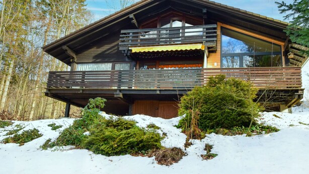 A wooden cabin with a balcony, surrounded by snow and trees. - Fliederweg by Interhome (Siegsdorf)