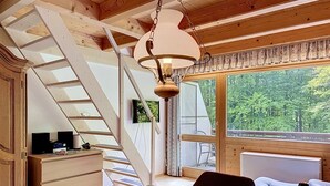A wooden interior with a staircase, a dining table with apples and wine, and a view of greenery outside. - Fliederweg by Interhome (Siegsdorf)