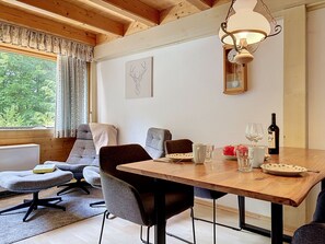 Ein gemütlicher Essbereich mit Holztisch, Stühlen und einer Pendelleuchte.
