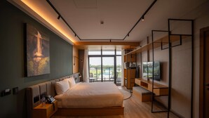 Een moderne hotelkamer met een groot bed, een televisie en een balkon met uitzicht.
