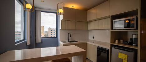 A modern kitchen with a large island, stainless steel appliances, and a city view.