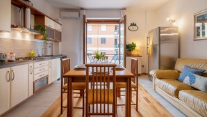 Una cocina compacta con una mesa de comedor, sillas y un sofá.