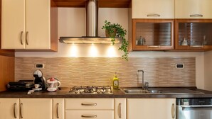 Una cocina moderna con estufa integrada, cafetera, extractor de jugos y lavavajillas.