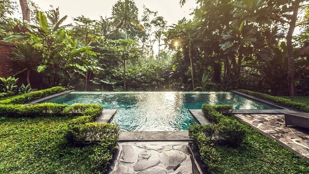 A rectangular swimming pool with clear water, surrounded by lush greenery and stone pathways. - Jungle Villa - Two Bedroom Villa, Sleeps 4 (Sayan)
