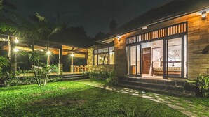 A modern house with a well-lit exterior, a paved driveway, and a small garden area. - Jungle Villa - Two Bedroom Villa, Sleeps 4 (Sayan)