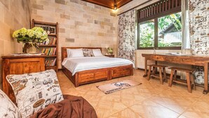 A cozy bedroom with a wooden bed, a desk, and a bookshelf. - Jungle Villa - Two Bedroom Villa, Sleeps 4 (Sayan)