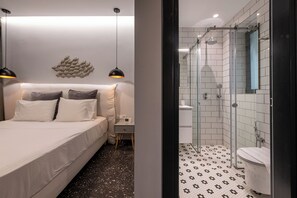 A modern bedroom with a bed, bedside table, and a wall-mounted light fixture. - Modern Private Pool Villa • Walk to Beach (Kalamata)