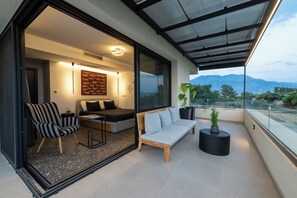 Un balcón moderno con sofá, sillón y planta en maceta.