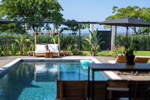 A swimming pool with lounge chairs and a wooden bench, surrounded by greenery and a view of the sea. - Modern Private Pool Villa • Walk to Beach (Kalamata)