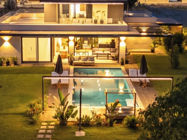 A modern two-story house with a swimming pool, outdoor seating, and a well-maintained garden. - Modern Private Pool Villa • Walk to Beach (Kalamata)