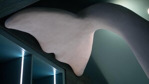 Et moderne interiør med en unik skulpturel lampe og en stilfuld, mørk væg.