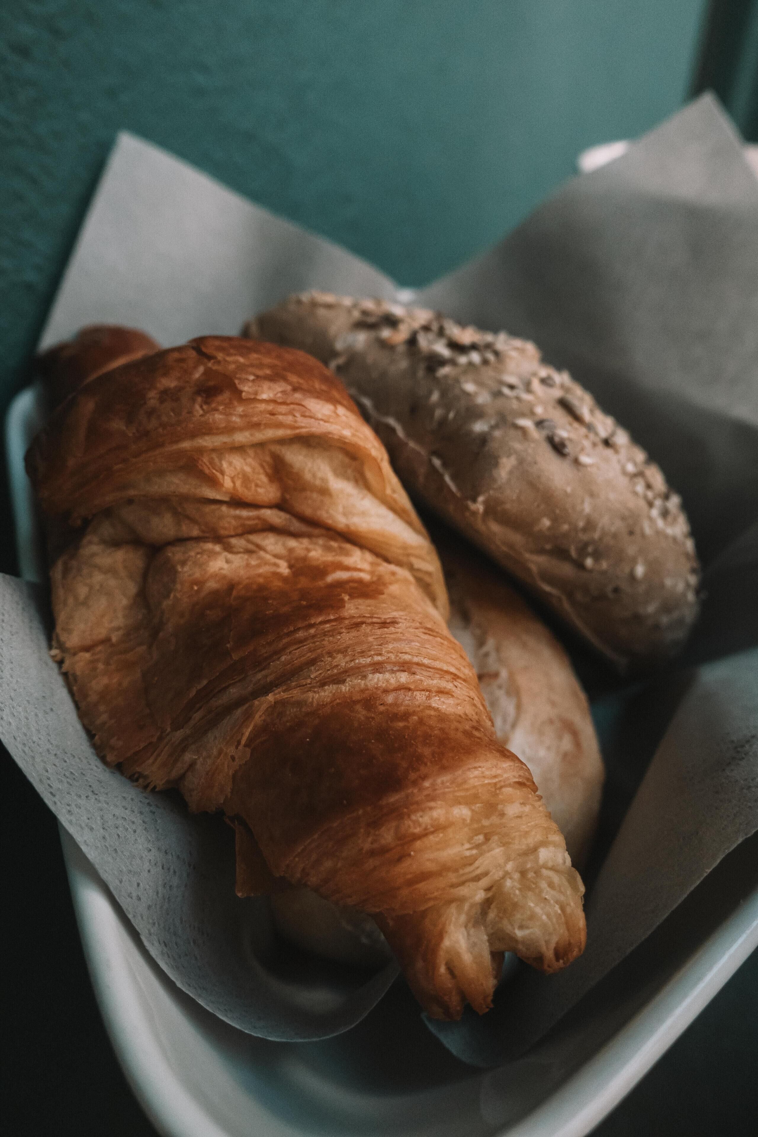 A tray with a croissant and a sandwich.