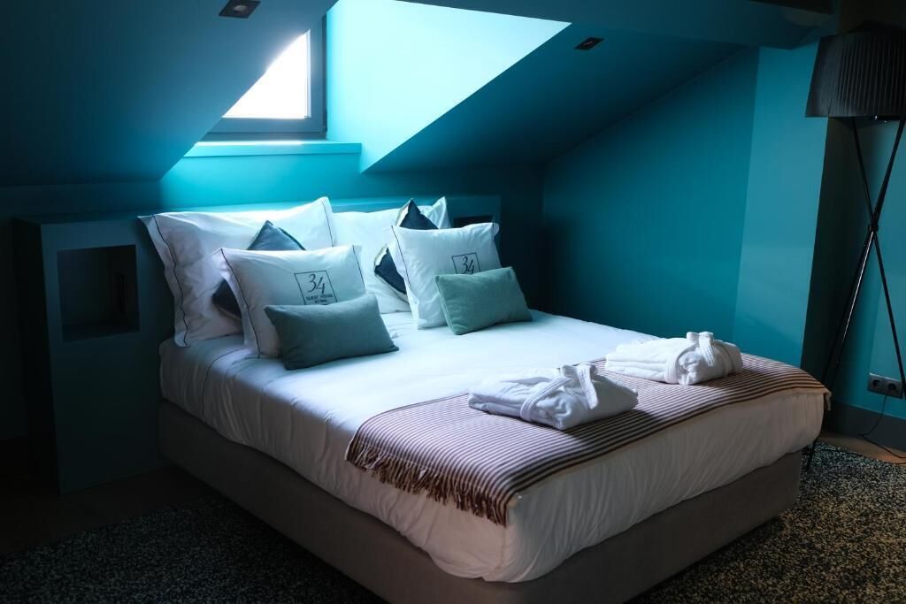 A bedroom with a bed, pillows, and a towel.
