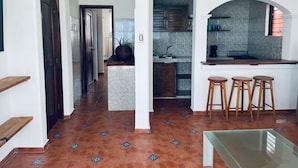 A modern kitchen with a marble countertop, wooden stools, and a tiled backsplash. - Beautifull Apartment beach front & nice sea view (Cancun)