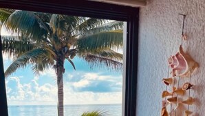 A room with a view of the sea, a tiled floor, and a hanging decoration. - Punta me beautifull Apartment beach front (Cancun)