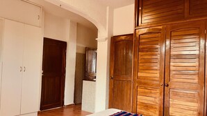 A bedroom with a bed, a wooden wardrobe, and a white wardrobe. - Punta me beautifull Apartment beach front (Cancun)