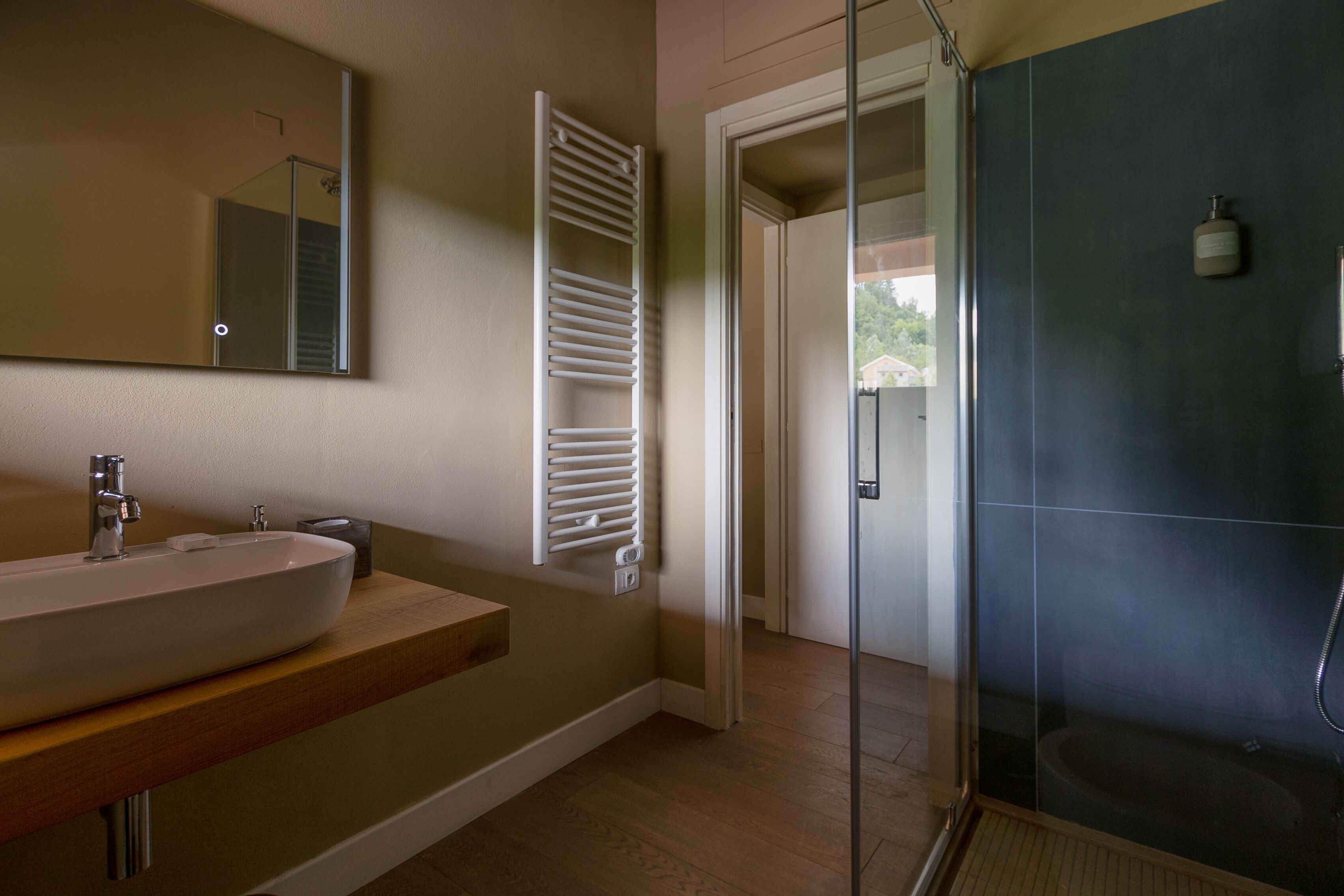 Un baño con un lavabo grande, un espejo, toallero y zona de ducha.