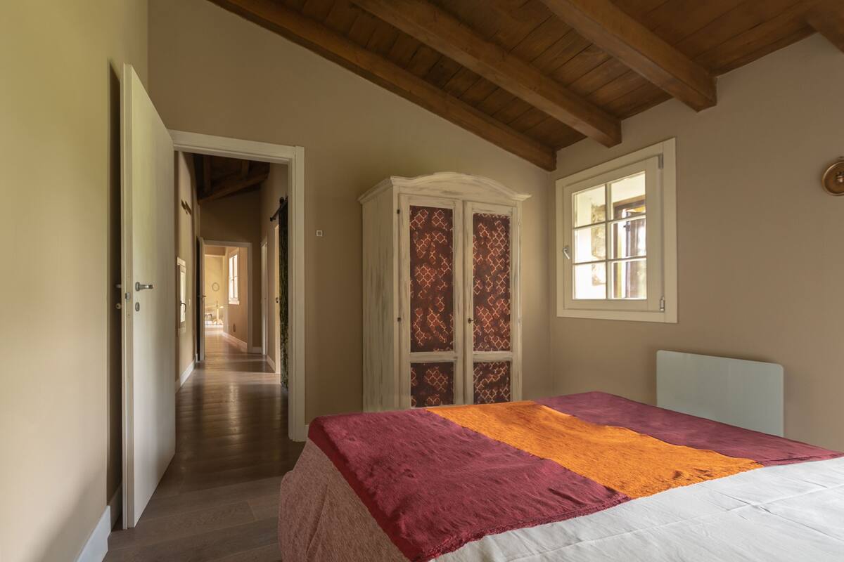 A bedroom with a bed, a wardrobe, and a window.