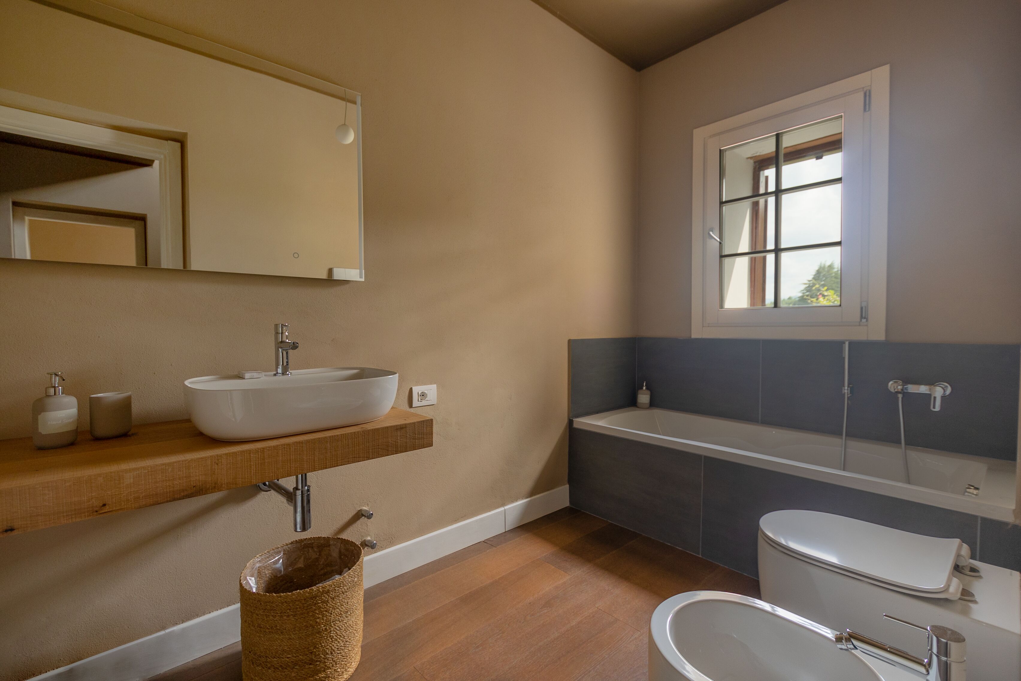 Un baño moderno con un lavamanos grande, una bañera y un inodoro.