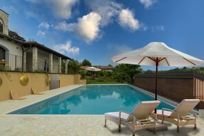 Piscine extérieure, parasols de plage, chaises longues