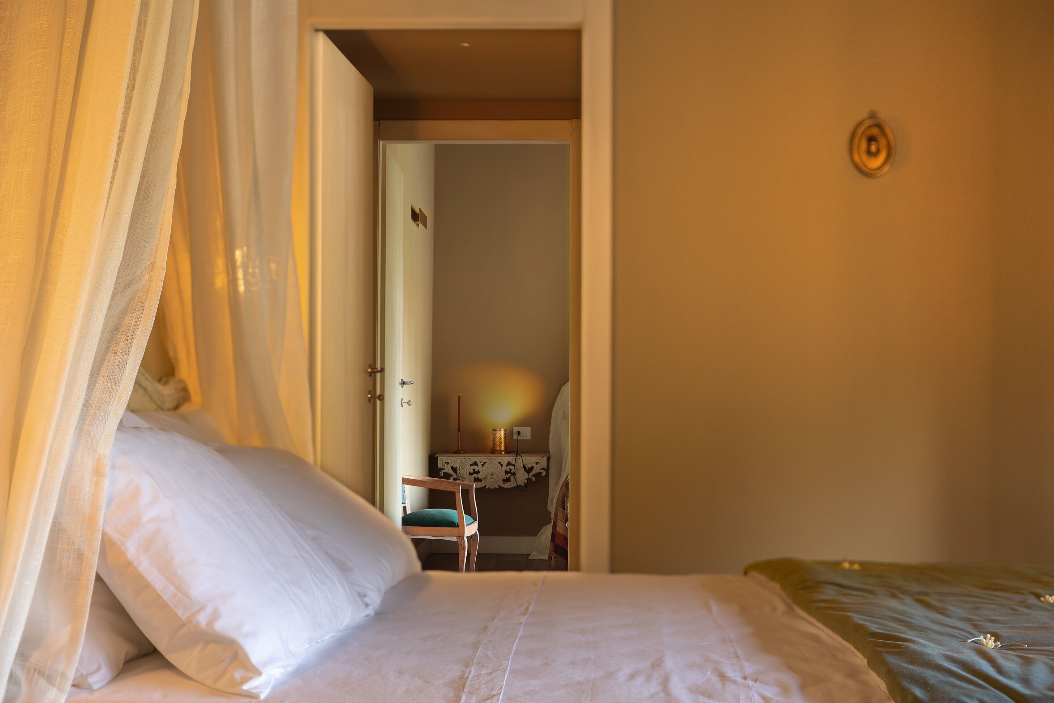 A bedroom with a bed, a chair, and a desk.