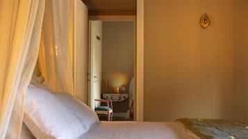 A bedroom with a bed, a chair, and a desk.