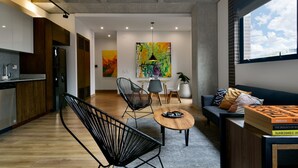 A modern living room with a sofa, chairs, a coffee table, and a bookshelf.