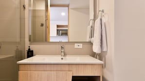 A modern bathroom with a large sink, a mirror, and a towel rack. - w Magnificent Loft w City View in Santa Barbara (Bogotá)
